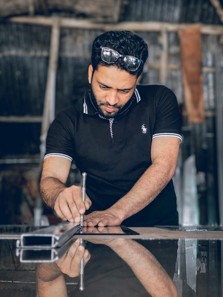 pexels-photo-11626073-11626073 A skilled craftsman focusing on cutting glass in a workshop using precision tools.