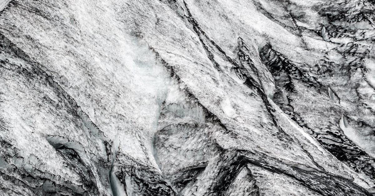 A detailed aerial shot of glacial ice and rock formations showcasing natural textures.